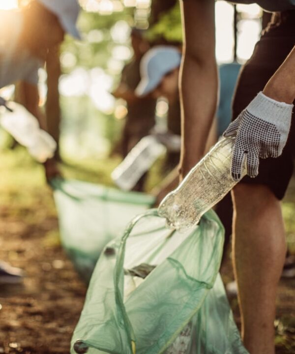 Group of multi-ethnic people, people with differing abilities , volunteers with garbage bags cleaning park area